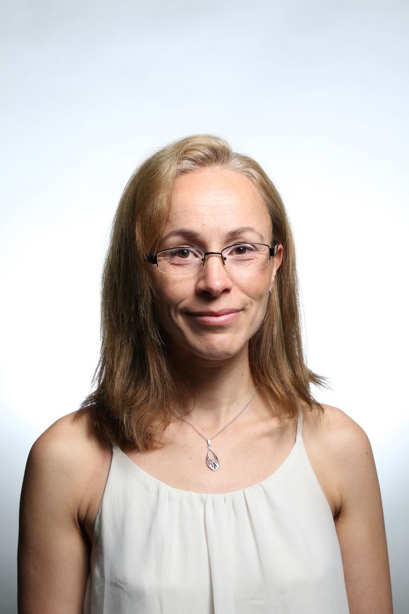 Head shot of Dr Kate Ellacott - brown hair, white top